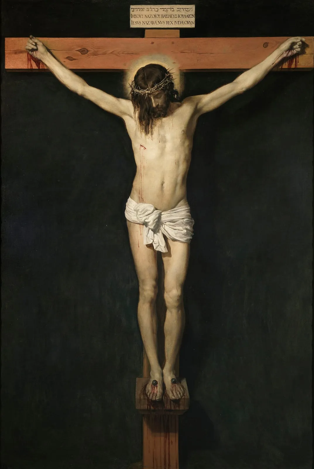 Jezus przybity do krzyża na ciemnym tle, z pochyloną głową i przepaską na biodrach
